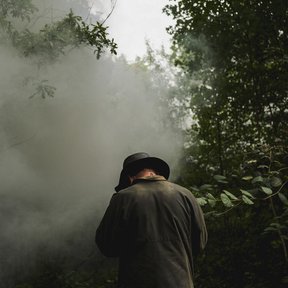 Volunteer photographed at a charcoal burn, Kenley Common, 2025
