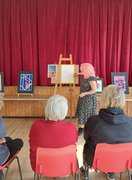 One of our tutors demonstrating how to paint a circus-themed poster in gouache